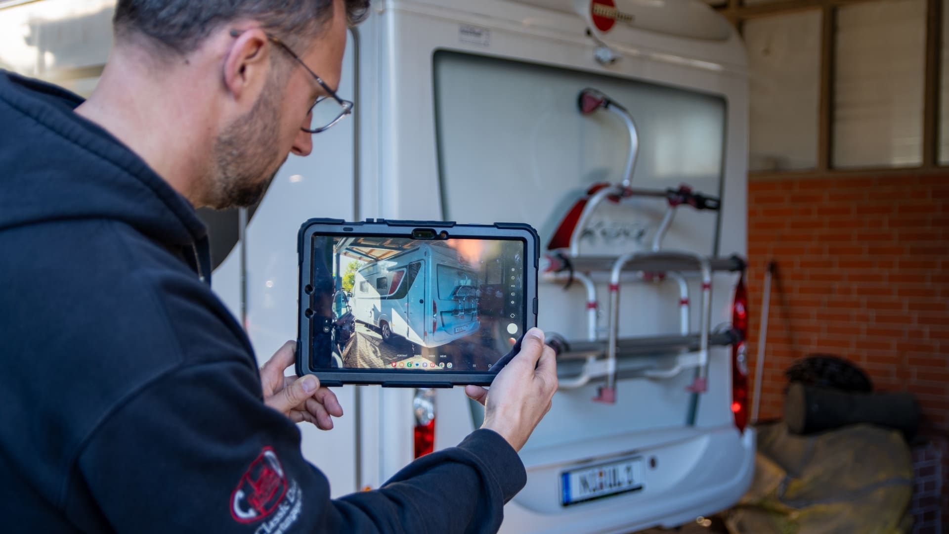 Sachverständiger dokumentiert ein Reisemobil mit einem Tablet