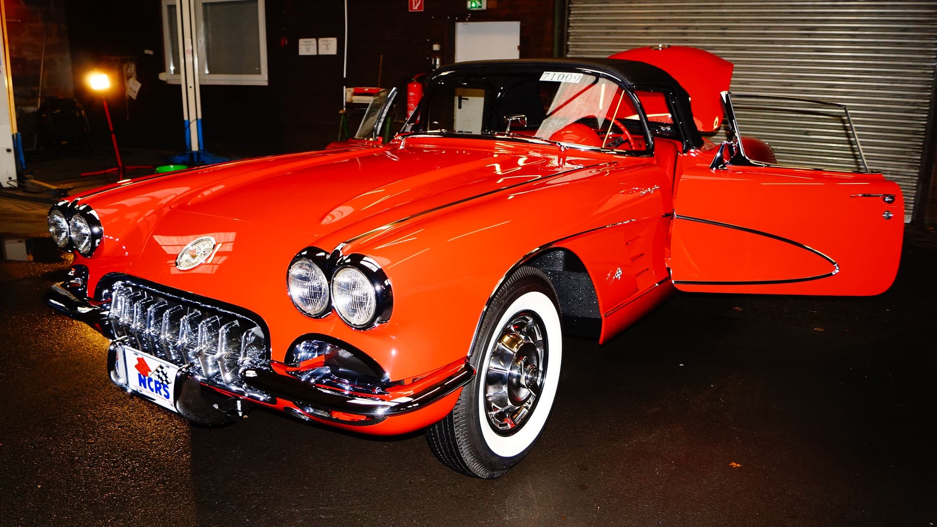 Roter Oldtimer-Sportwagen in einer Werkstatthalle